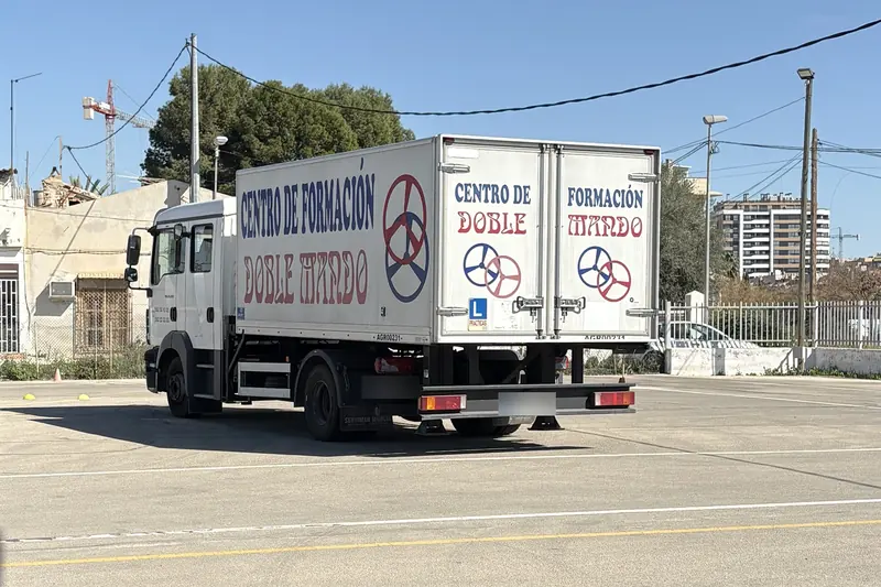Camión de prácticas de Autoescuela Doble Mando, rotulado, en la pista de El Puntal